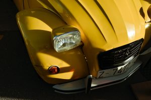 Engine Light Flashing yellow volkswagen beetle on road during daytime