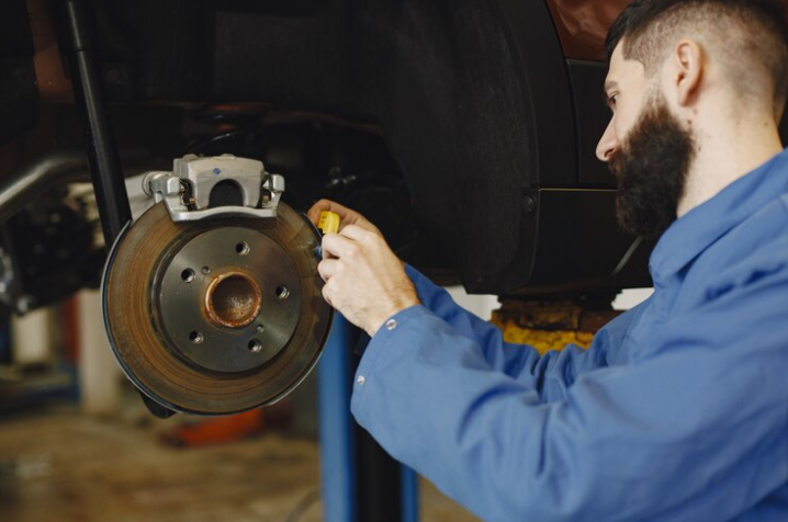 Free Photo Free photo mechanic with a tool wheel in hands of a mechanic blue work clothes