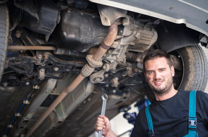 Free Photo Free photo portrait of car mechanic with wrench tool working under the vehicle in car repair shop